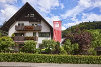 Sparkasse Kinzigtal, advertising banner Sparkasse, trees, hedge, hilly landscape with coniferous