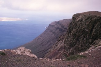 Steile Küstenklippen Risco de Famara mit Blick nach Norden auf die Insel Graciosa, Lanzarote,