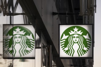 Illuminated Starbucks logo reflected in window pane, city centre, Copenhagen, Denmark, Europe