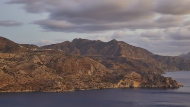 Mountainous coast with a view of the sea and clouds under a clear sky, morning light, sunrise,