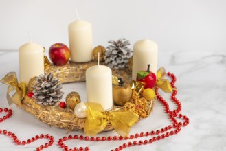 Christmas Advent wreath with white candles, golden decoration and red beads