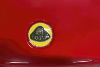 Close-up of logo of car brand sports car manufacturer Lotus from 2010 to, 2019 on red bonnet bonnet