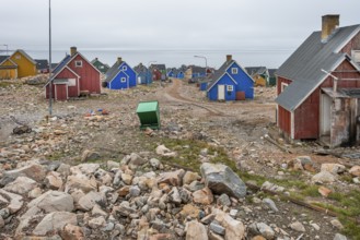 Colourful houses and gravel road under an overcast sky on a fjord, remote Arctic Inuit settlement