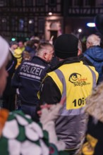 Crowd of people, including police and organisers, gather at night for an event, carnival, Calw,