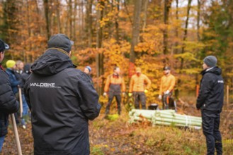 People in the forest, some in orange clothes, autumn scene, tree planting campaign, Waldbike Calw,