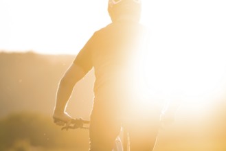 Person riding a bicycle with intense sunlight in the background, e-bike, forest bike, Calw,