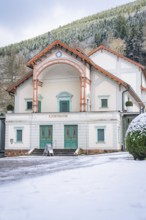 Historic theatre building in the snow, surrounded by wooded mountains, Königliches Kurtheater, Bad