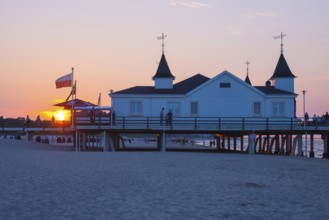 People strolling on a pier with buildings in the sunset, clear, blue, cloudless sky, pier Ahlbeck