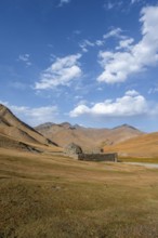 Historic caravanserai Tash Rabat from the 15th century, with yellow hills, Atbashy district in the