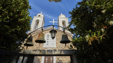 Three church bells in front of a stone wall under a deep blue sky, Koroni, Byzantine fortress,