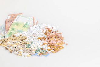 Piles of pills and banknotes on a white background, copy room