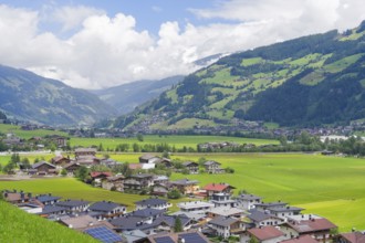 Alpine village with many houses and green hills, surrounded by majestic mountains, Mayrhofen,