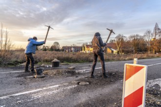 Climate activists chop up the asphalt of a road to erect obstacles, barricades, to prevent the