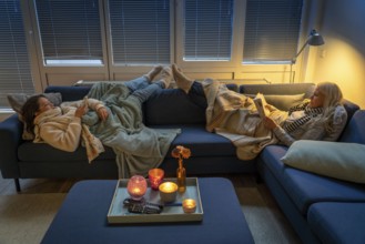 Symbolic image energy saving, cold winter, energy crisis, cold flat, mother and daughter lying on