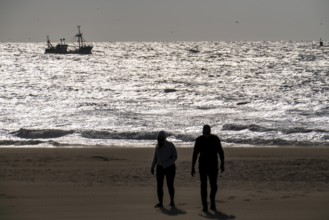 Strollers on the beach of Scheveningen, shrimp cutter, Netherlands