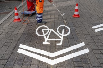 Application of road markings for a cycle lane, Rüttenscheider Straße in Essen, in the shopping and