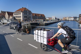 Cyclists on the Inderhavnsbroen cycle and footpath bridge, over the harbour, at Nyhavn, Copenhagen