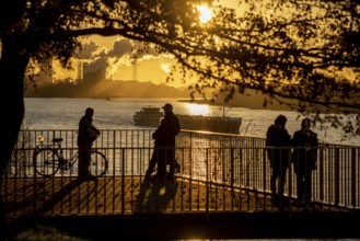 Rhine promenade in Duisburg-Wanheim, sunset, view of the Rhine and Hüttenwerke Krupp Mannesmann,