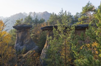 Three striking rocks in the evening light, surrounded by forest and hilly landscape in autumn, rock