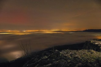 Firework lights under the sea of fog. New Year's Eve fireworks 2024 and a little red Aurora