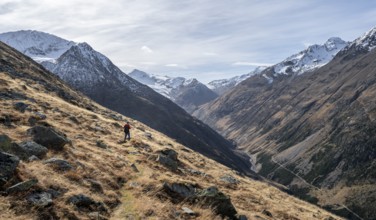 Mountaineers on a hiking trail, view over the Niedertal valley with snow-covered mountain peaks of