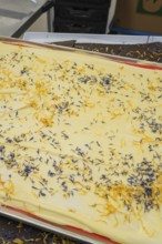 White chocolate on a tray garnished with yellow and blue flowers, Burch Schokolade production,