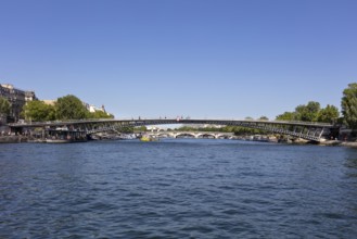 Modern bridge over a river with urban surroundings and natural backdrop, Paris