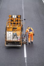 Marking work after the application of new whisper asphalt surface for the A40 motorway, in the