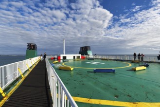 Passengers on sun deck, helipad on a ferry between Ireland and Wales, spring clouds, Ireland,