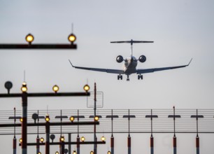 Aircraft approaching the main runway south, 05R/23L, runway lighting, approach aids, at Düsseldorf