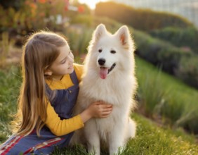 A girl with long hairin girl hugs a white dog lovingly in a sunny, natural setting, dog puppy,