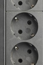 Close-up of sockets in a black socket strip