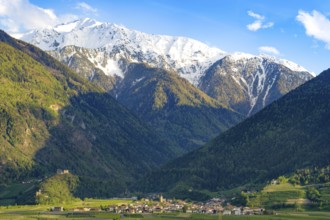 View of the village of Morter with the mountains of the Stelvio National Park behind it, evening