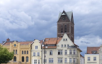 Historic houses on the market square, behind the remaining tower of St Mary's Church, Wismar,