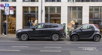 Charging station for electric vehicles, BMW SUV and Smart small car charging on the street,