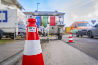 Traffic cone on a busy road with background traffic, Wend Glasfasermontage during the installation