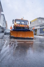 Snow plough in action on a wet road during a winter's day, Sindelfingen, Germany, Europe