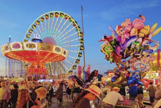 Lots of people at the Cranger Kirmes in front of the Wellenflug and the Ferris wheel, Herne, Ruhr