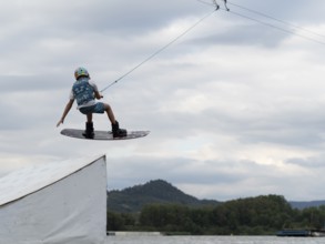 Boy with wakeboard, jump over obstacle, water sports, water skiing and wakepark, Stráž pod Ralskem,