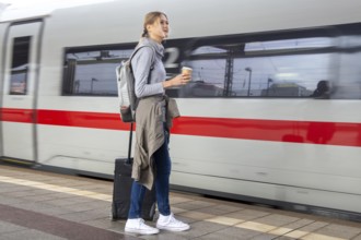 Young woman on the railway track while a train arrives