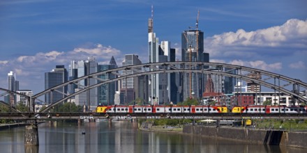 The river Main with regional railway on the Deutschherrnbrücke and the skyline of Frankfurt am