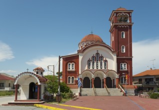 A Greek Orthodox church with a red roof and bell tower under a clear blue sky, Church of St