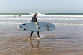 People surfing in Atlantic Ocean on beach, Taghazout, Morocco, North Africa, Africa