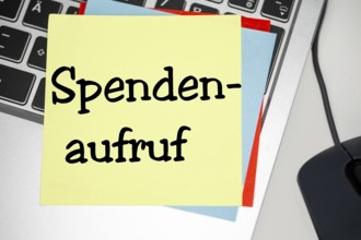 Notepad with the inscription SPENDENAUFRUF on a laptop