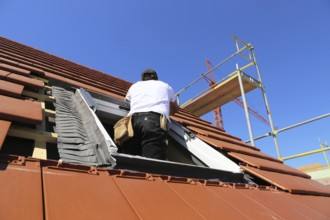 Employees of Zimmerei Mellein GmbH install the roof windows in the Mutterstadt development area,