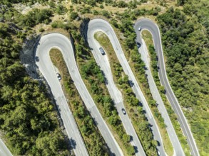 Mountain pass road with multiple hairpins, water pipeline, aerial view, drone shot. Valais,