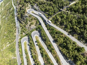 Mountain pass road with multiple hairpins, water pipeline, aerial view, drone shot. Valais,