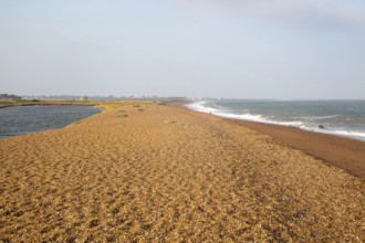 North Sea coastline view of shingle ridge and lagoon on beach bar, Shingle Street, East Lane,