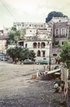 People and taxis at the Plaza bus stop, Hotel Colonia, Taxco, Guerrero state, Mexico, 1961, Central