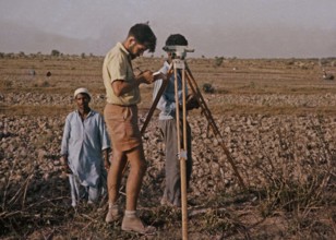 A Western European surveyor works on a technical project in rural Pakistan 1962